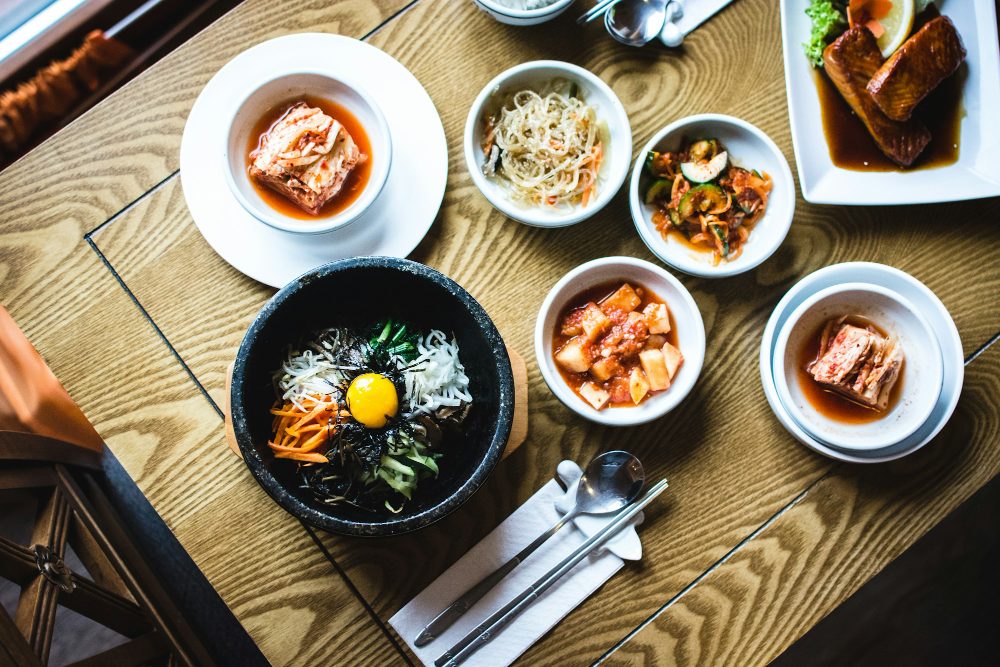 나무 식탁 위의 돌솥비빔밥과 반찬들